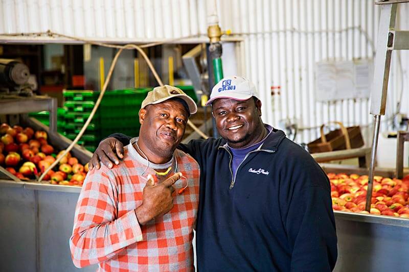 father and son migrant workers smile for the camera