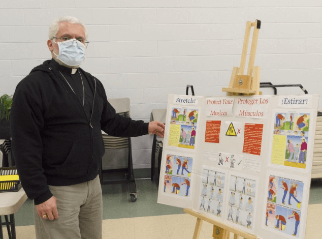 Masked man standing in front of a poster board