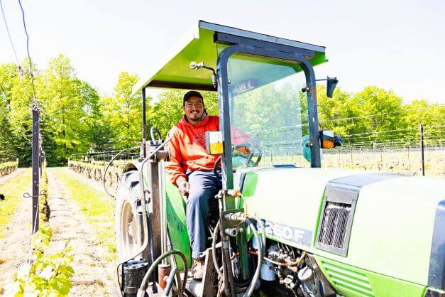 male migrant worker sitting in tractor