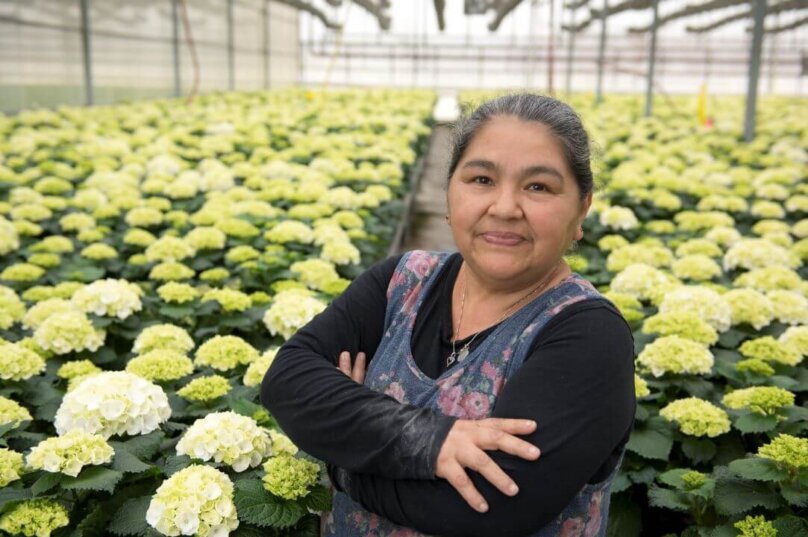 female farm employee poses for camera