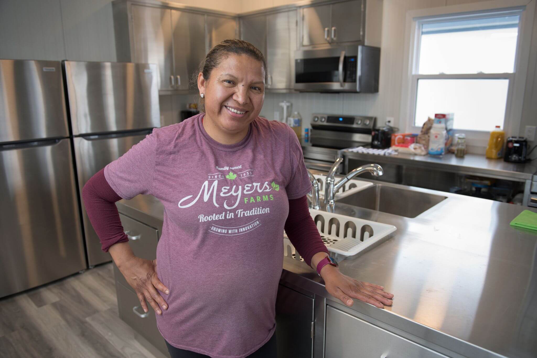 female migrant farm worker posing in new housing unit