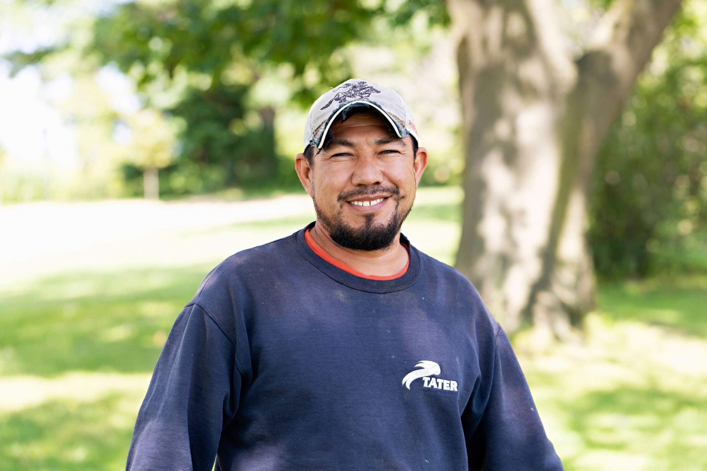 male farm employee smiles for camera