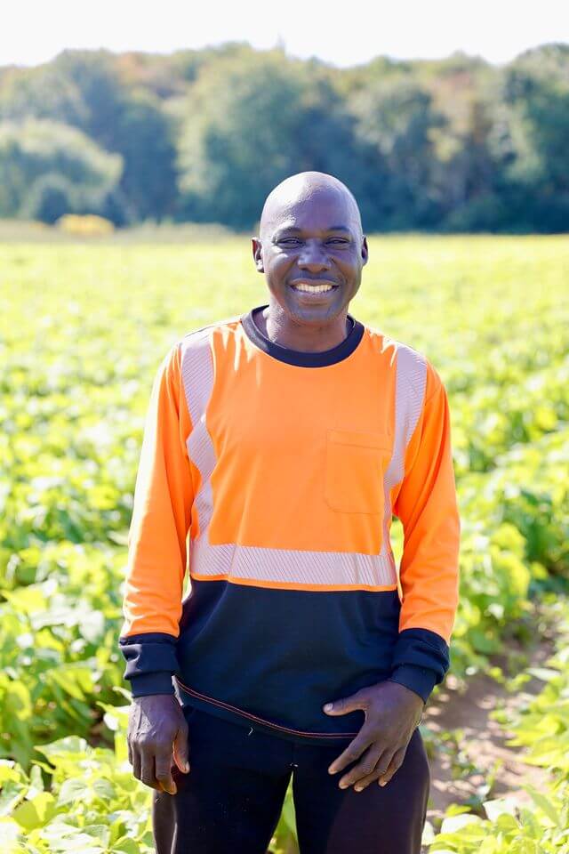 farm employee smiles for camera